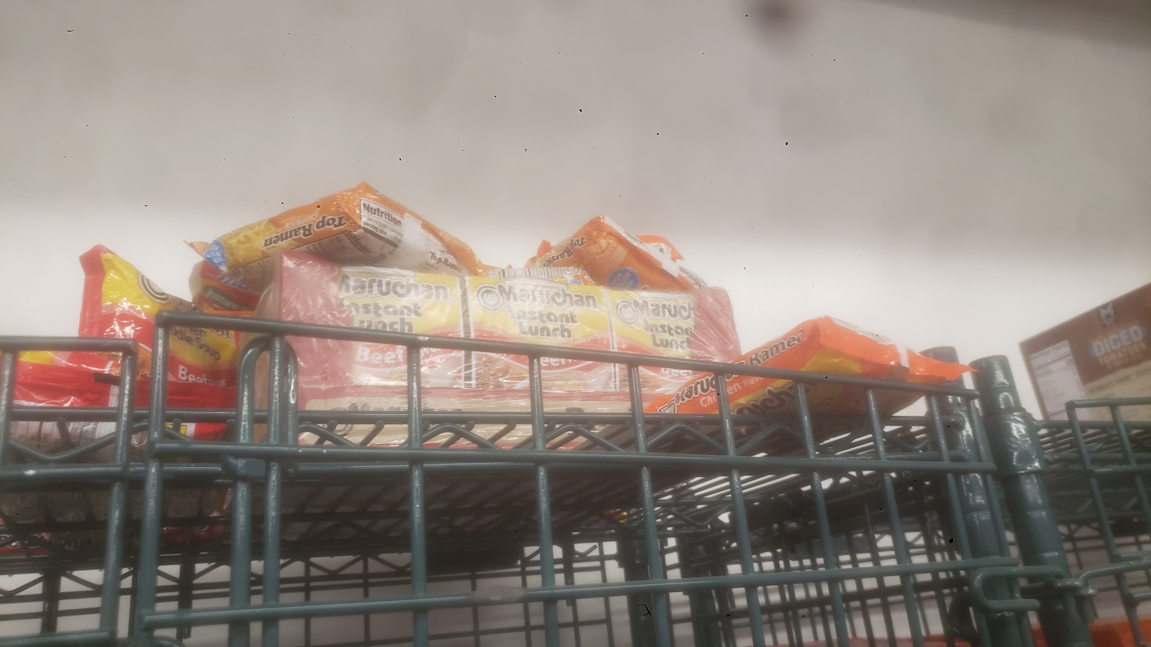 Pack of ramen noodles on top of a cage shelf.